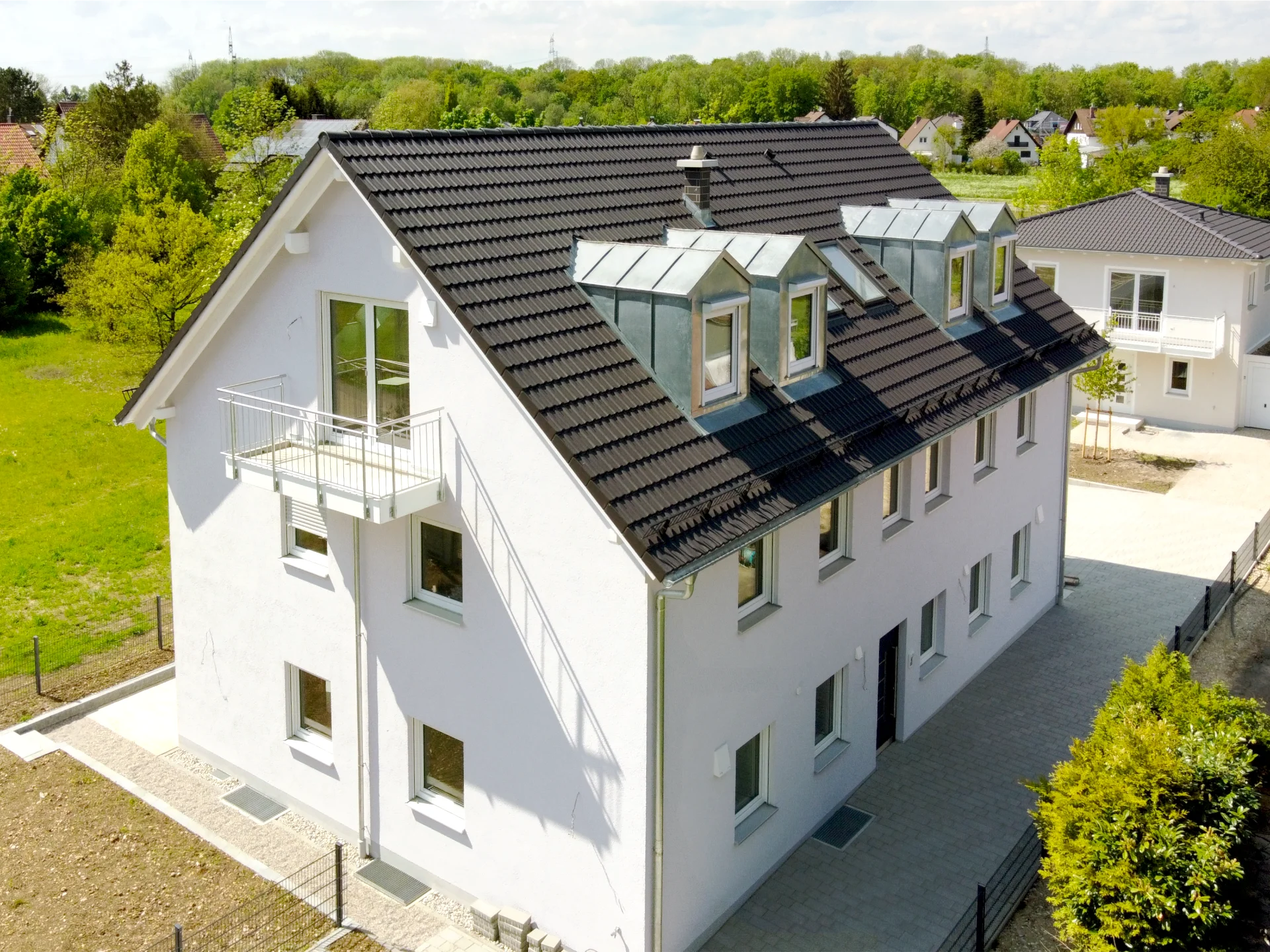 Außenaufnahme (Drohne) eines kleinen Mehrfamilienhauses (Neubau) im Nordwesten Münchens mit Einfahrt und angrenzenden Grünflächen