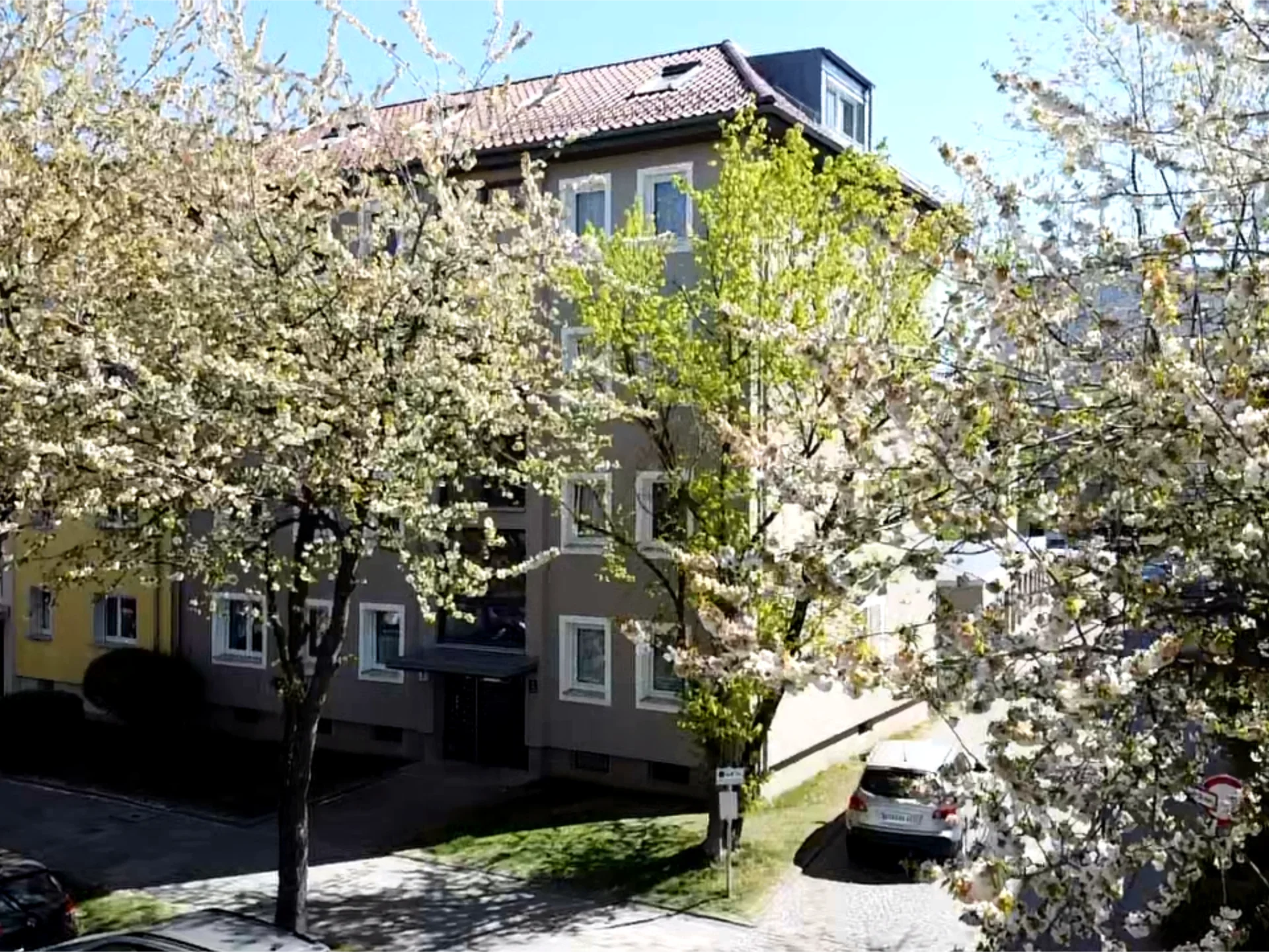 Außenaufnahme viergeschossiges Mehrfamilienhaus mit angeschlossenen Garagen